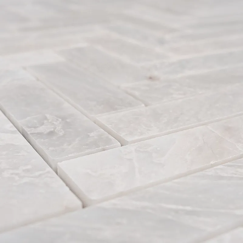 Detailed shot of Iceberg Herringbone 1x3 polished marble mosaic, highlighting the natural stone texture and sophisticated polished finish.