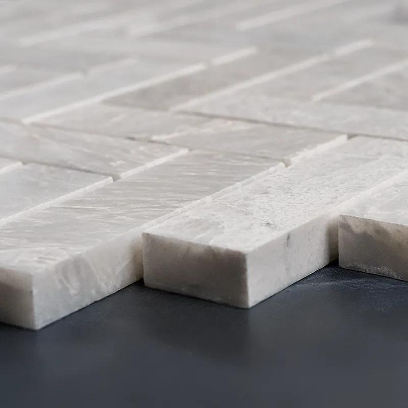 Angled perspective of Iceberg Herringbone 1x3 marble mosaic tiles with a polished finish, displaying the elegant pattern and smooth edges for versatile design applications.