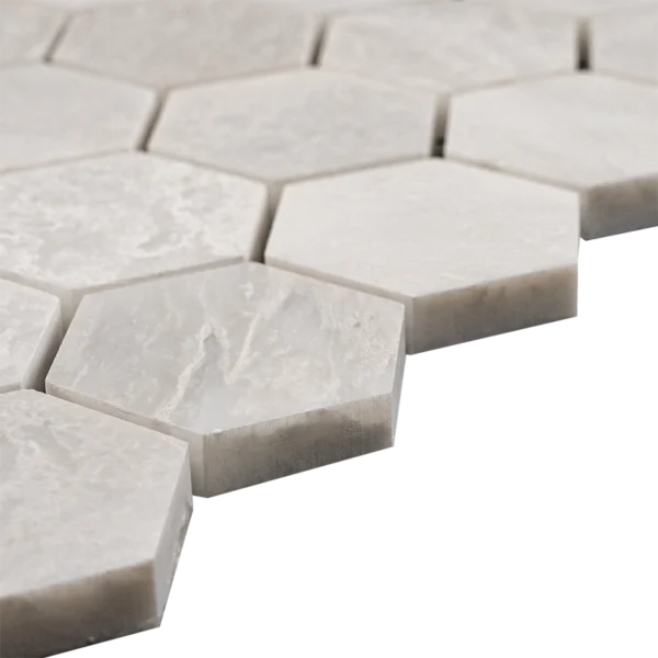 Side view of 2-inch honed Iceberg marble honeycomb mosaic tiles showing white hexagon shape, thickness, and soft matte surface.