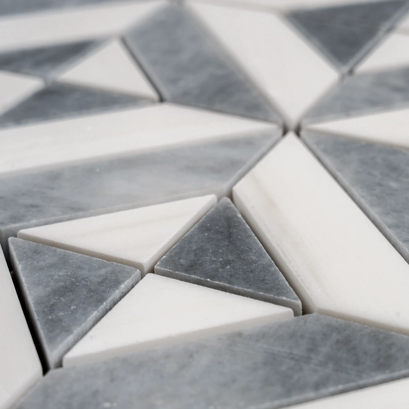 Detailed shot focusing on the crisp grout lines and symmetrical diamond design of the white and gray marble tile.