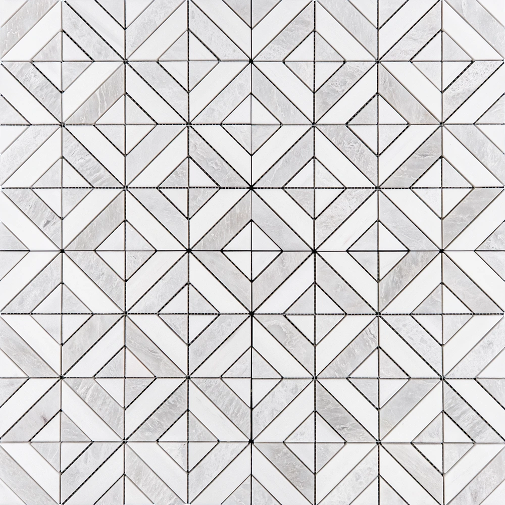 A white and gray geometric marble tile design, showcasing a repeating pattern of diamonds and triangles. The polished surface and natural veining add texture and dimension.