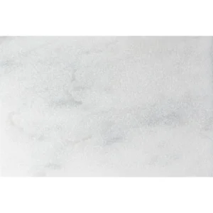 Close-up view of Avalon White marble paver with leather finish, showcasing subtle grey veining and a softly textured surface in 12x24 size