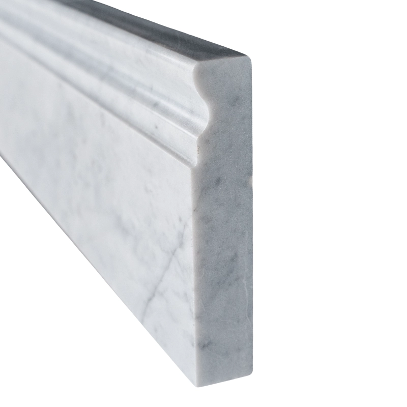 End profile of Carrara marble baseboard trim revealing edge curvature and thickness.